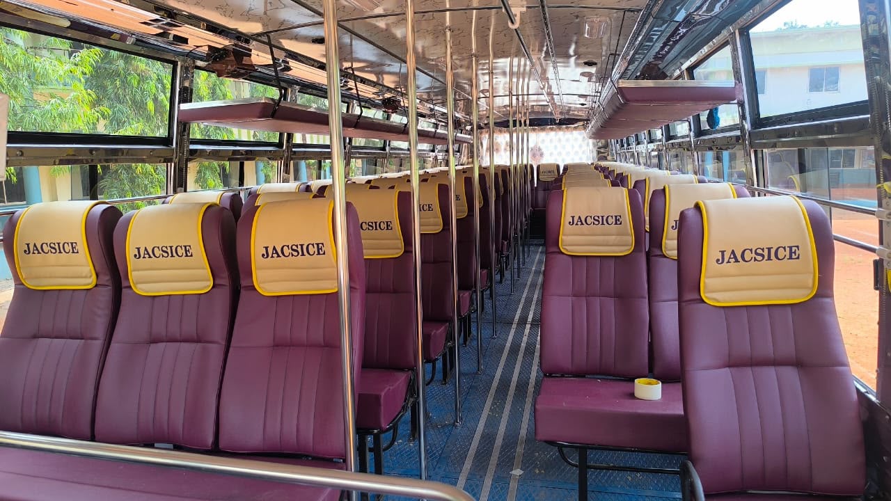 Maroon and cream JACSICE branded bus seating interior finished by Alfha Coach Builders, Karur